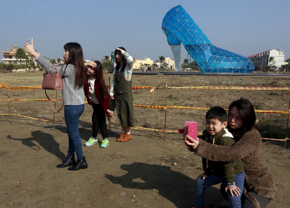People take selfies in front of a  shoe-shaped church in Chiayi