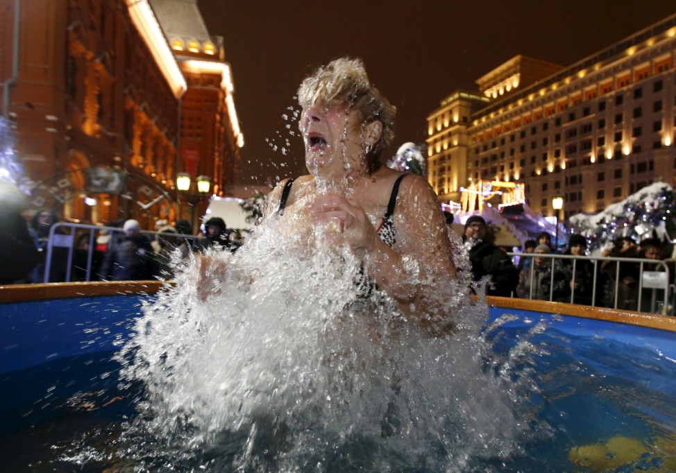 A woman takes a dip in a font on the eve of the Orthodox Epiphany in central Moscow, Russia