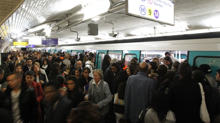 Commuters crowd into a train at Saint-Lazare metro station in Paris