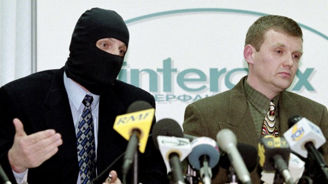File photo of Litvinenko, then officer of Russia's state security service FSB, listening as masked colleague speaks during news conference in Moscow