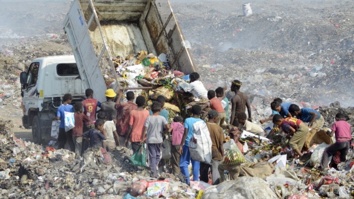 People collect recyclable waste at a rubbish dump outside Yemen's Red Sea port city of Houdieda