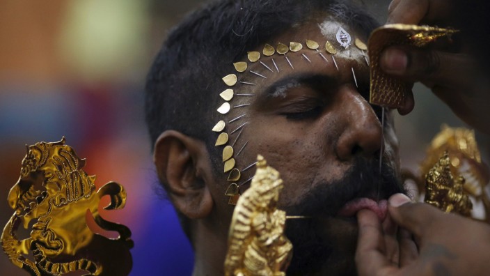 A devotee has his tongue pierced during Thaipusam festival in Singapore