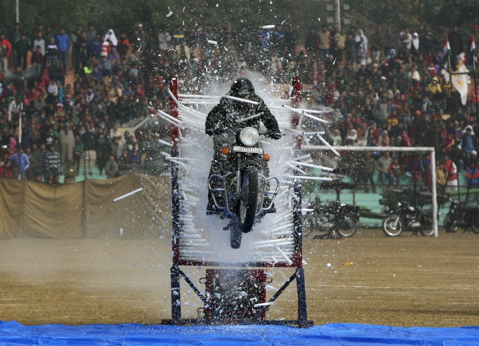 An Indian policeman performs a stunt on his motorcycle during the Republic Day parade in Jammu