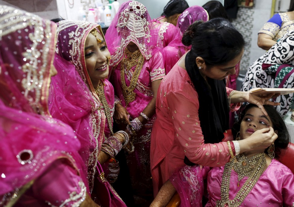 A Muslim bride gets her make-up done as others wait at a beauty parlour before the start of a mass marriage ceremony in Mumbai