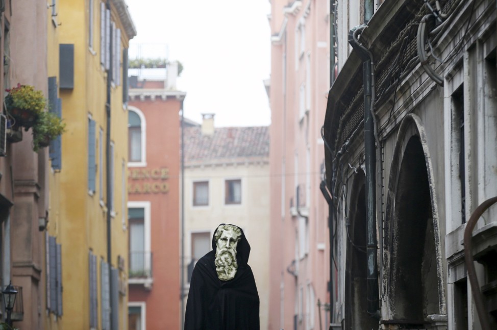 A masked reveller poses at San Marco Piazza during the Venice Carnival