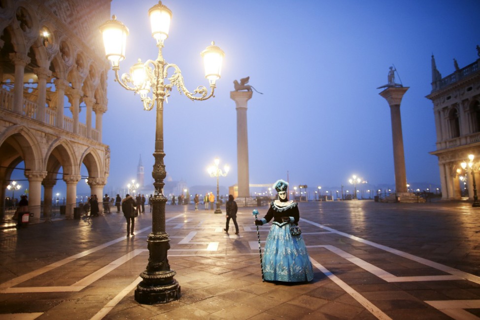 A masked reveller poses during the Venice Carnival, in Piazza San Marco