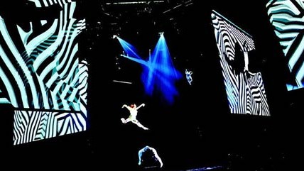 Cirque du Soleil in Las Vegas: Es sind Elitetruppen, in denen jeder ein Großmeister seiner Disziplin ist; unter ihnen finden sich olympische Goldmedaillengewinner. Sie werden auf der ganzen Welt gecastet. Der permanente Leistungsüberschuss sich ergänzender Spezialisten erzeugt  die Illusion, in eine Parallelwelt katapultiert worden zu sein.