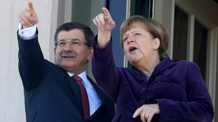 Merkel in Ankara: Ihre Finger weisen schon in dieselbe Richtung: Vom Balkon seines Palastes aus zeigt der Premierminister Davutoğlu seinem Gast das winterliche Ankara.