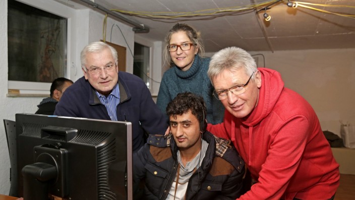 Icking: Die Ehrenamtlichen Reinhard Gebhardt, Laura von Beckerath-Leismüller und Bernd Hertwig (v. li.) zeigen einem Flüchtling den Sprachkurs am PC.