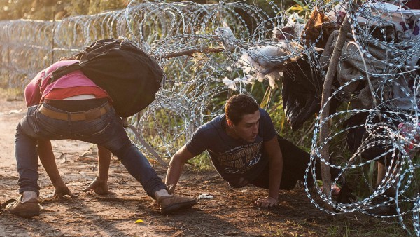 Flüchtlinge passieren Grenzzaun