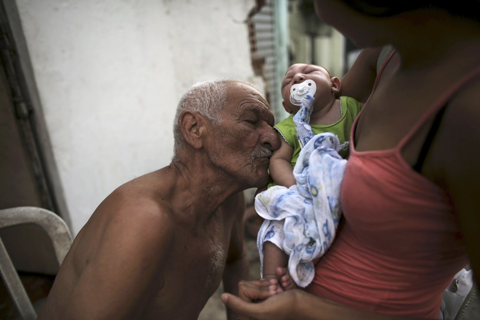 Great-grandfather Wilson kisses his great-grandson Juan Pedro who is 2-months old and born with microcephaly as his mother Daniele Santos holds him on a street in Recife