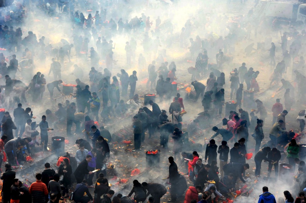 People burn incense to worship the God of Fortune at Guiyuan Temple on the fifth day of Chinese Lunar New Year in Wuhan