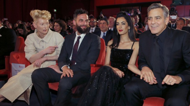 Actor Clooney his wife Amal actor Swinton and her partner Kopp take their seats for screening at opening gala of 66th Berlinale International Film Festival in Berlin