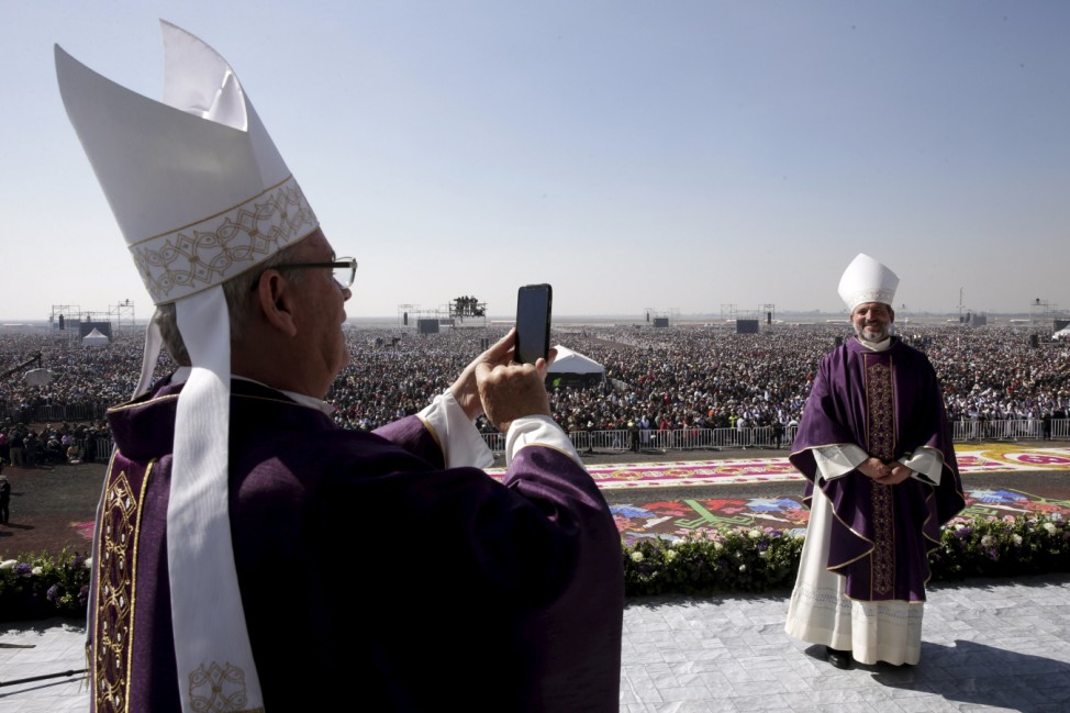 A member of the cleric takes a picture of another before a Mass celebrated by Pope Francis before a crowd of hundreds of thousands in Ecatepec, Mexico,
