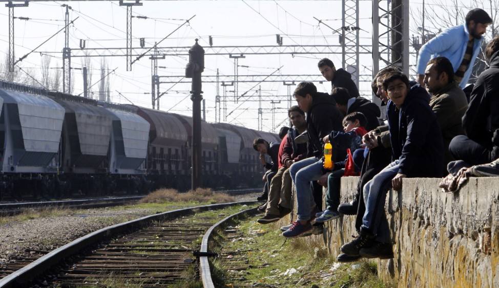 Flüchtlinge sitzen auf einem Bahnsteig an der Grenze von Mazedonien und Serbien