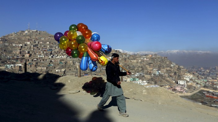 An Afghan man holds balloons for sale in Kabul, Afghanistan