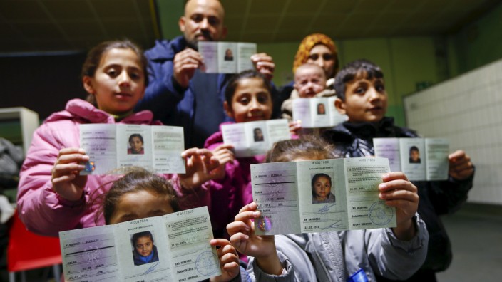 Syrian refugees present their newly issued initial German registration documents in Herford