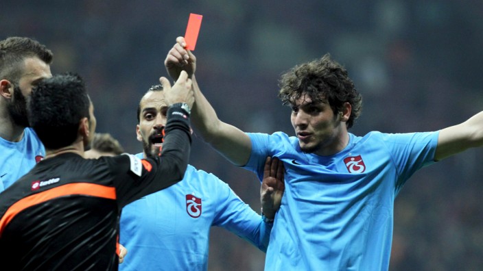 Trabzonspor's Salih Dursun shows a red card to referee Deniz Bitnel during the Turkish Super League soccer match between Galatasaray and Trabzonspor in Istanbul
