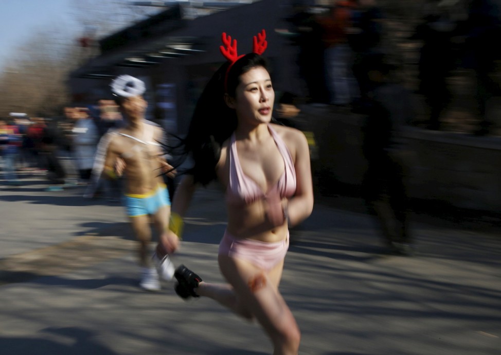 Participants run at the 'Half-Naked Marathon' at Olympic Forest park in Beijing