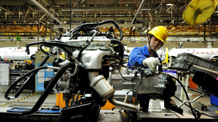 An employee works on an assembly line producing automobiles at a factory in Qingdao