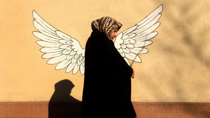 Wahl in Iran: Eine Frau geht in Teheran an einem Graffiti vorbei.