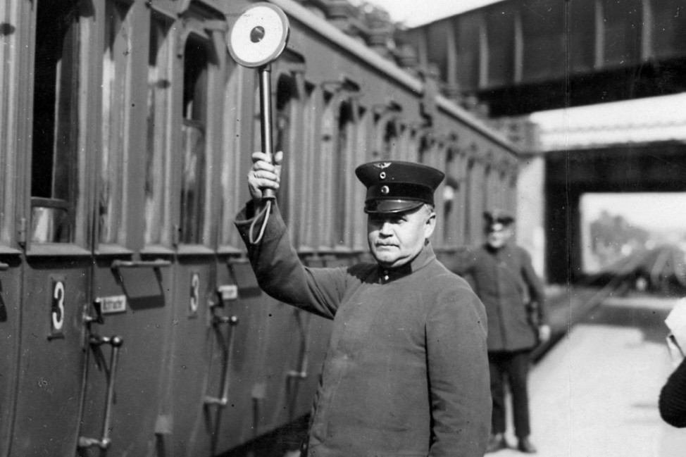 Bahnangestellter gibt die Abfahrt frei, 1930