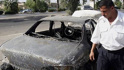 Irak: Ermittlungen gegen Blackwater: Besichtigungstermin am Tatort wenige Tage danach: Ein irakischer Polizist an einem ausgebrannten Autowrack, das Blackwater-Leute am 16. September 2007 in Brand geschossen hatten