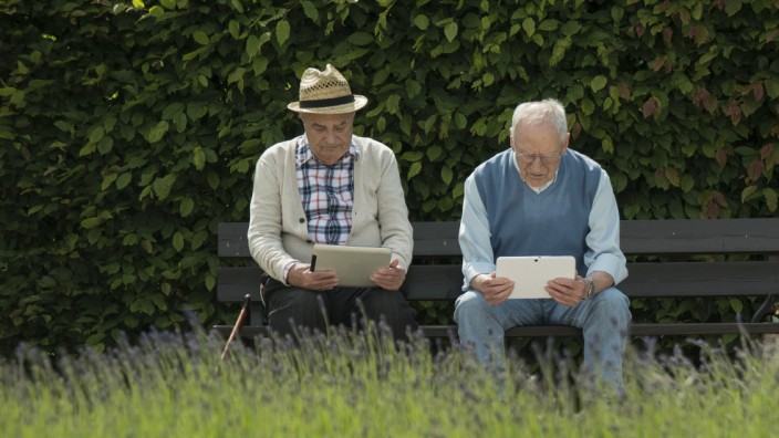 Two old men using tablet computers in the park model released PUBLICATIONxINxGERxSUIxAUTxHUNxONLY UU