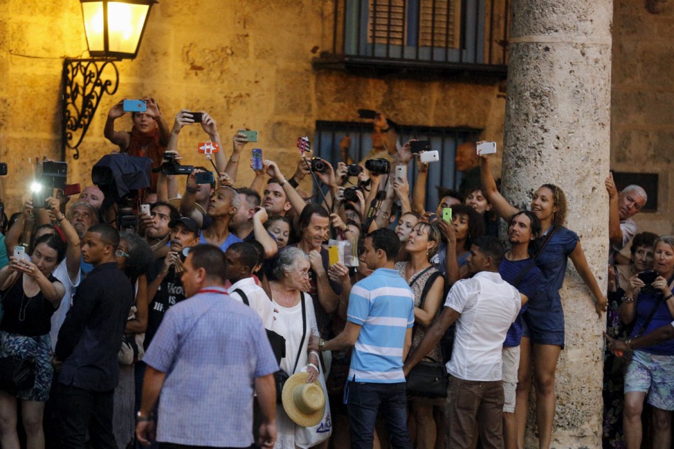 Tourists and local residents take pictures as U.S. President Barack Obama tours Old Havana with his family at the start of a three-day visit to Cuba, in Havana