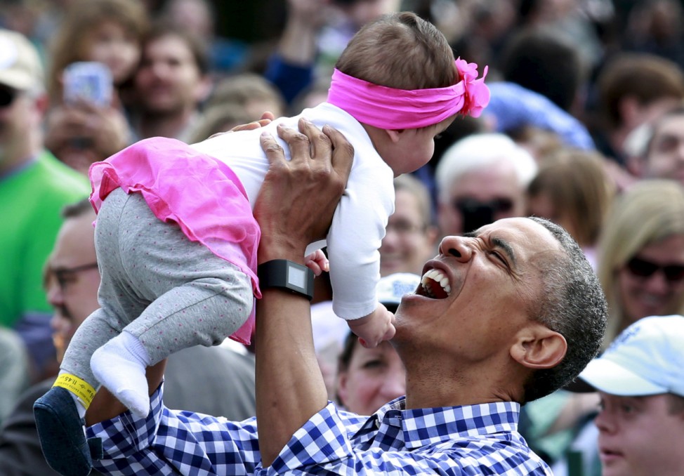 President Barack Obama holds a baby during the 2016 White House Easter Egg Roll on the South Lawn