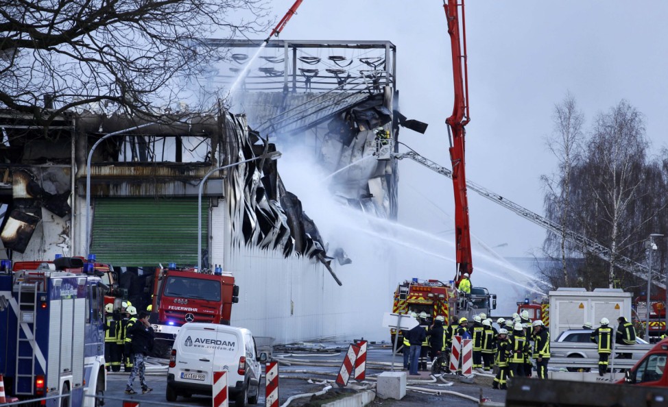 Fire fighters extinguish a fire at the area of poultry producer Wiesenhof in Lohne, western Germany