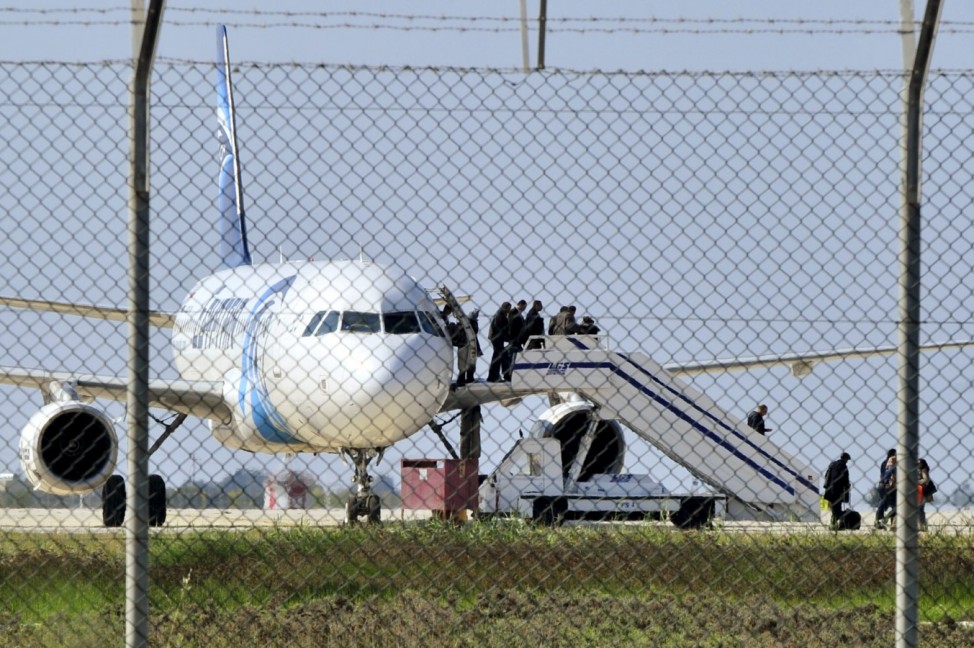 Passengers evacuate a hijacked EgyptAir Airbus 320 plane at Larnaca airport