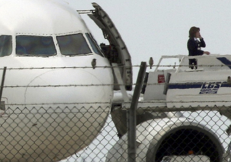 An official telephones from the ramp of a hijacked EgyptairA320 Airbus at Larnaca Airport