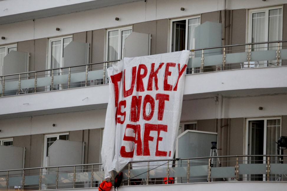 A banner hung by activists on a hotel reads 'Turkey is not safe' during a protest against the return of migrants to Turkey, at the port of Mytilene on the Greek island of Lesbos