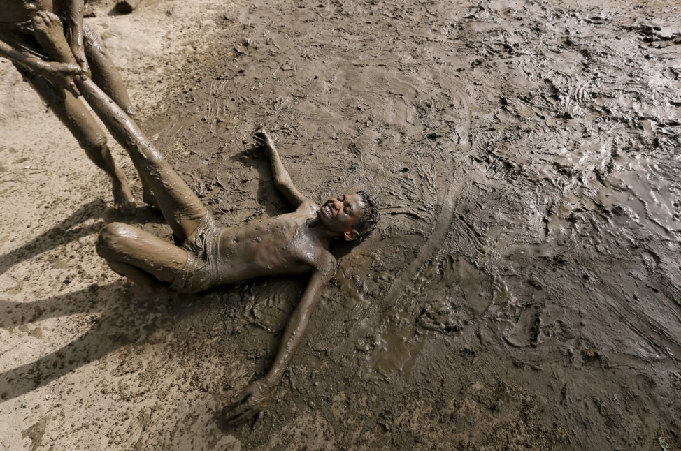 Children play in mud to cool off on a hot day in New Delhi