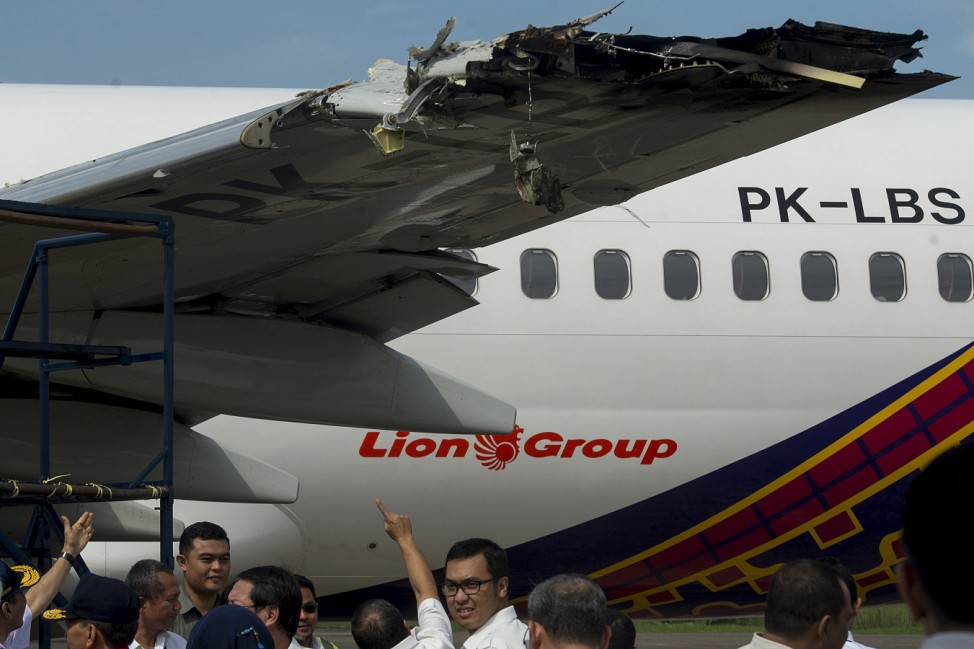 Officials and investigators from the Ministry of Transportation examine the wing of a Batik Air Boeing 737-800 damaged in a collision yesterday with another plane while on the runway at Halim Airport in Jakarta, Indonesia