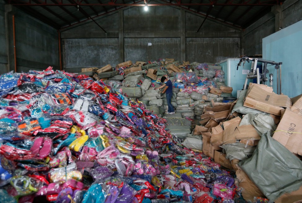 Workers destroy counterfeit goods