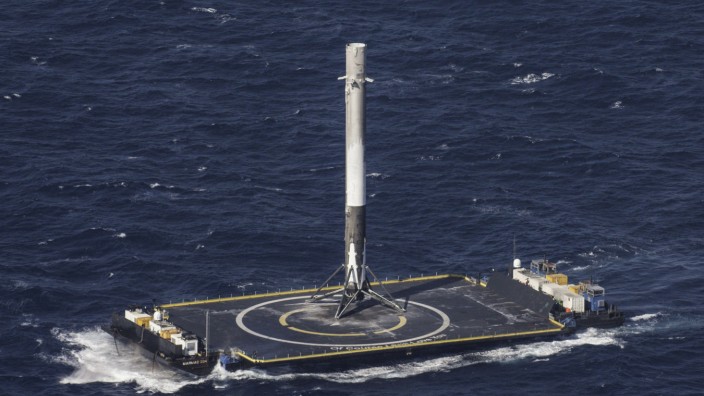 Handout photo of the reusable main-stage booster from the SpaceX Falcon 9 makes a successful landing on a platform in the Atlantic Ocean about 185 Nautical miles off the coast of Florida