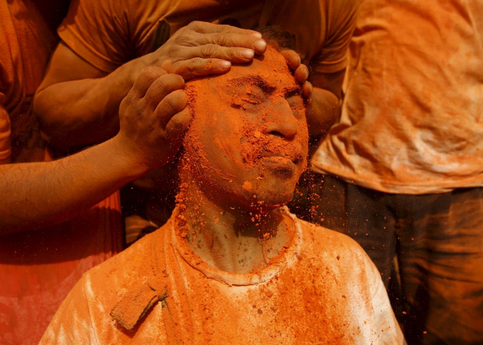 A devotee is smeared with a vermillion powder while celebrating 'Sindoor Jatra' vermillion powder festival at Thimi
