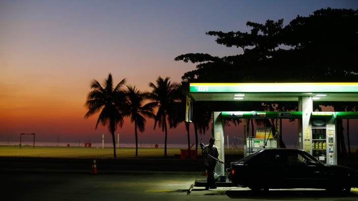 A worker prepares to fill a car at a gas station close to Copacabana beach in Rio de Janeiro
