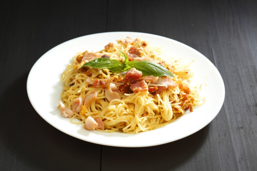 Spaghetti carbonara with fried bacon Spaghetti carbonara with fried bacon in plate on black table PU