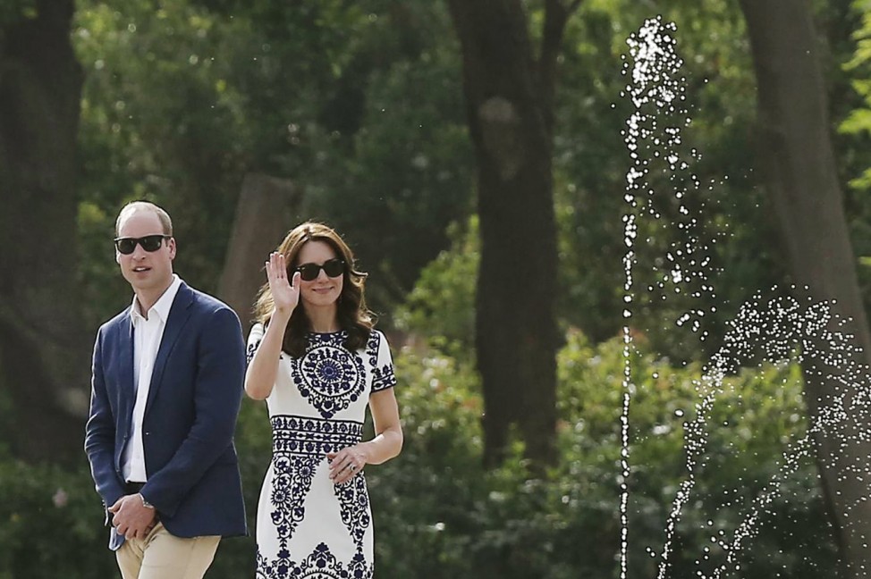 Catherine, the Duchess of Cambridge, waves as Britain's Prince William looks on during their visit to the Taj Mahal in Agra