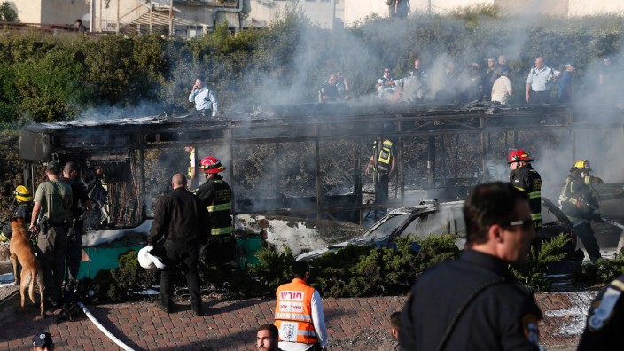 Israel: Löscharbeiten an dem ausgebrannten Bus.
