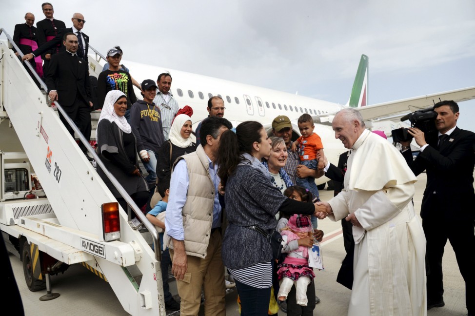 Pope Francis welcomes a group of Syrian refugees after landing at Ciampino airport in Rome following a visit at the Moria refugee camp in the Greek island of Lesbos