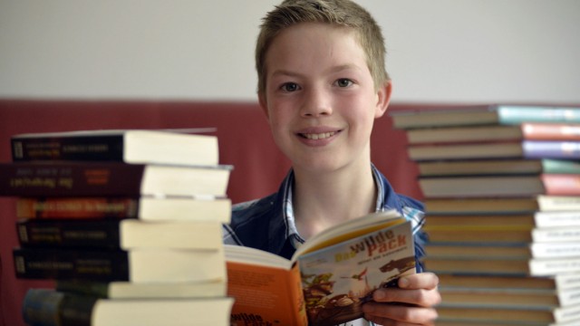 Welttag des Buches: Der Leser Adrian Baumeister hinter einem Stapel Bücher.
