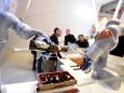 Robots in the Kuka stand pour a beer into a glass at the Hannover Messe industrial trade fair in Hanover