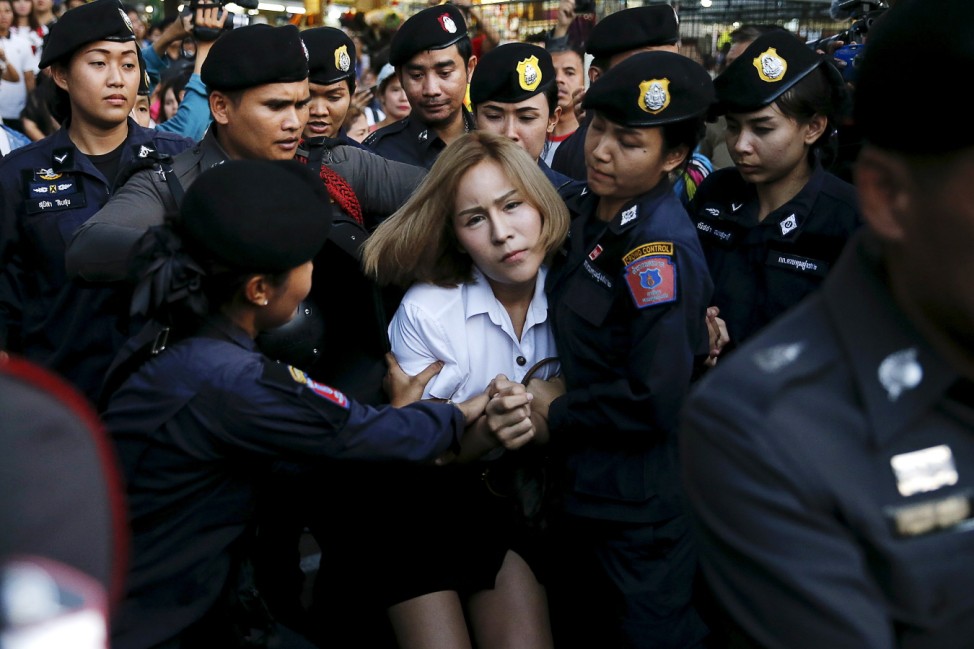 A student activist is detained during a silent protest in Bangkok