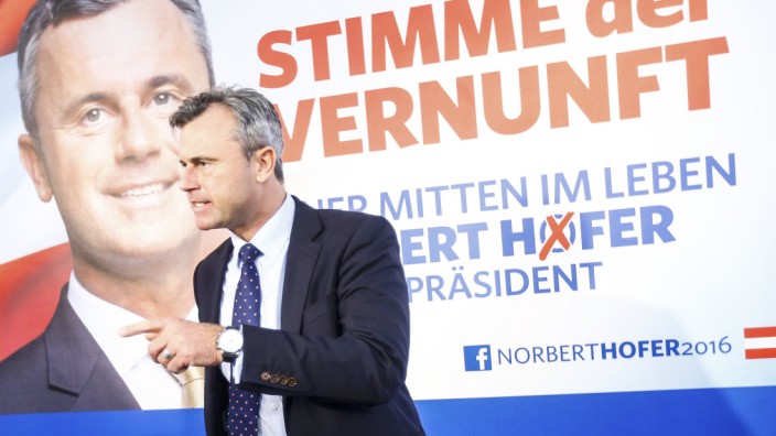 Presidential candidate Hofer presents his new electoral posters during a news conference in Vienna