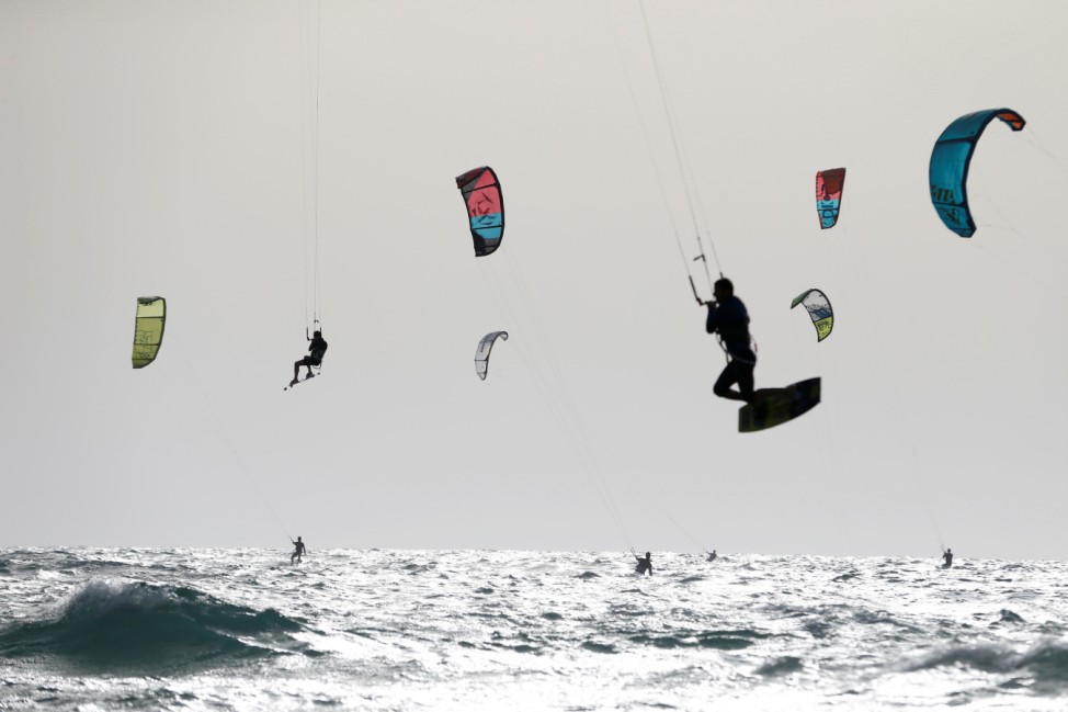 People kitesurf in the Mediterranean sea in Tel Aviv