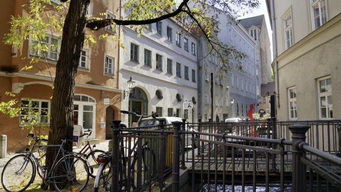 Porträts einer Stadt: Die rote Brecht-Figur markiert das Geburtshaus des in Augsburg geborenen Dichters, gelegen im von Kanälen durchzogenen Lechviertel.